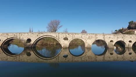 Wunderschöne-Spiegelreflexion-Des-Pont-Vieux-Am-Fluss-Orb.-Drohnenaufnahme-Von-Beziers